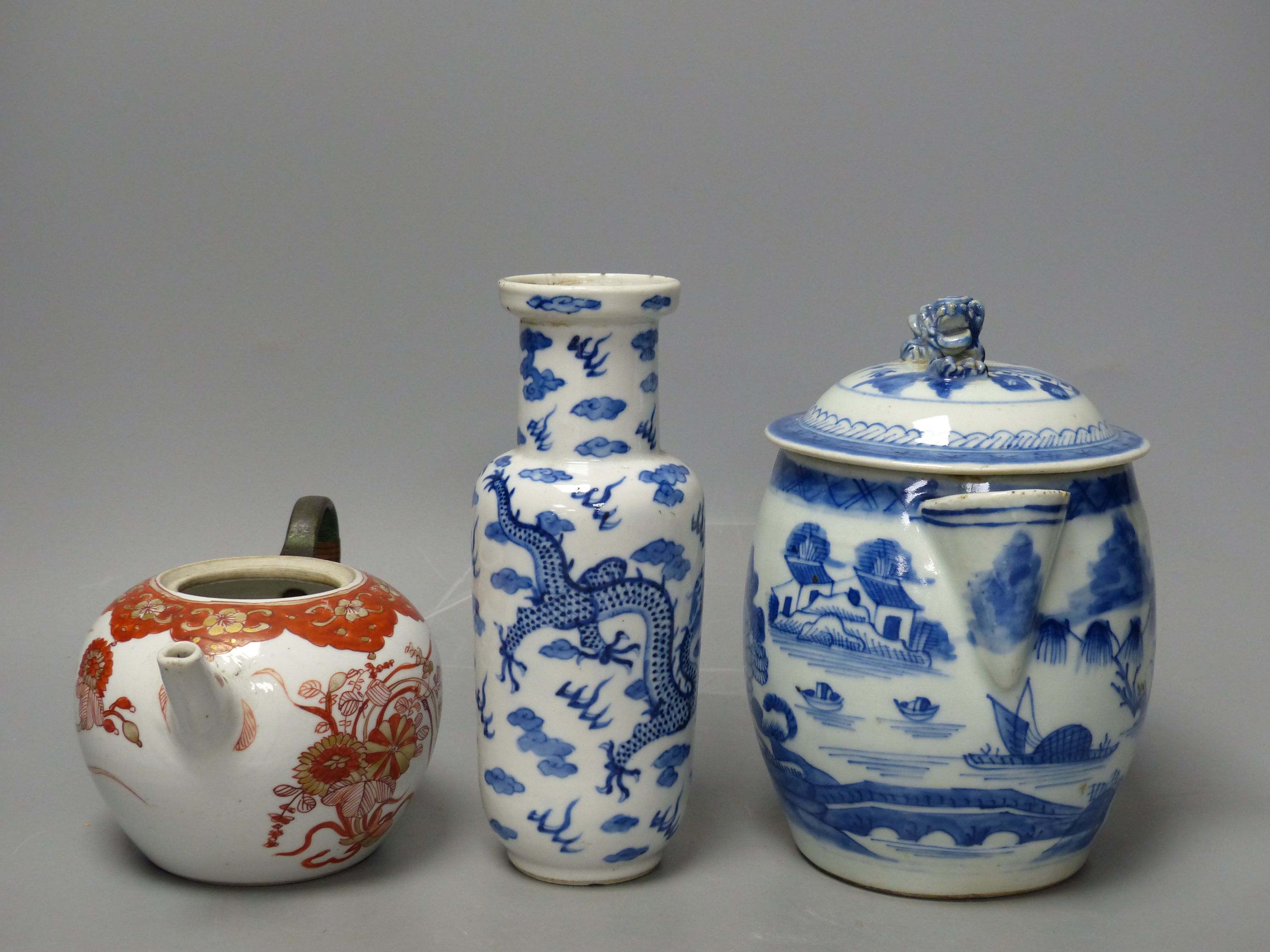 A 19th century Chinese blue and white covered jug, an early 20th century blue and white vase and a Kangxi rouge de fer teapot, tallest 18cm